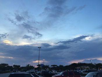 Traffic on road against cloudy sky