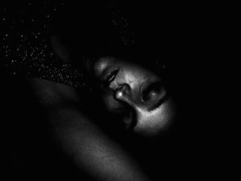 Close-up of young woman in the darkness
