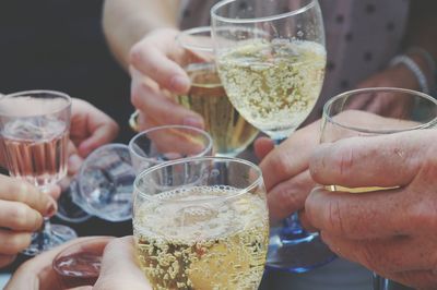 Close-up of people holding champagne and making a toast