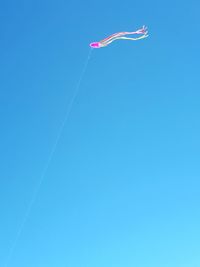 Low angle view of airshow against clear blue sky