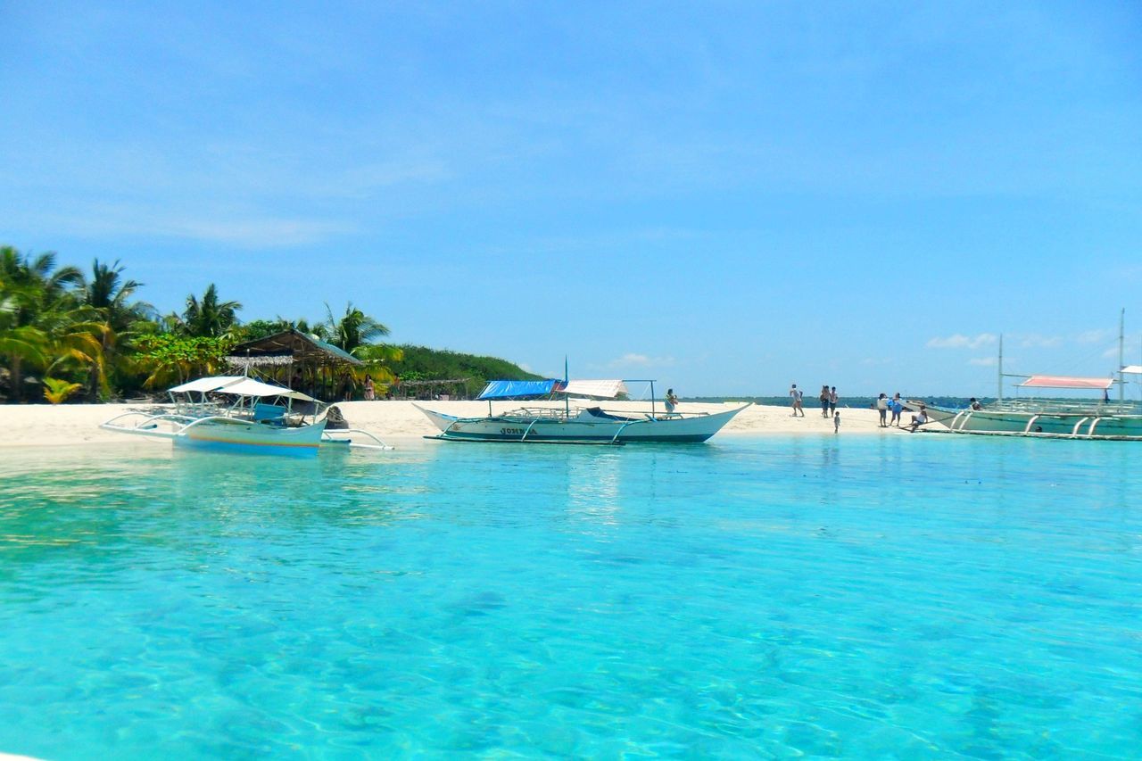 water, blue, nautical vessel, boat, transportation, waterfront, sea, moored, tranquility, mode of transport, tranquil scene, tree, nature, sky, turquoise colored, beauty in nature, scenics, day, clear sky, rippled