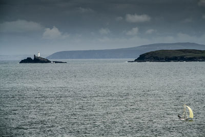 Scenic view of sea and mountains against sky