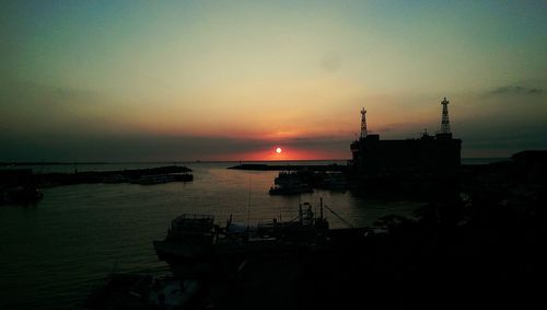 Boats moored on sea against sky during sunset