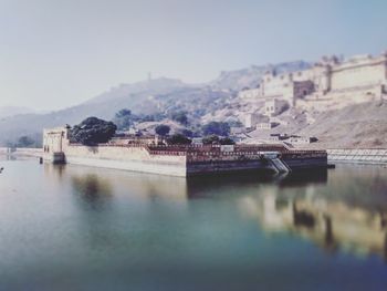 Scenic view of river by houses against sky