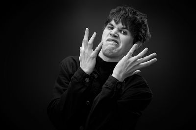 Portrait of young man against black background