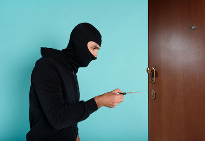 Side view of man standing against wall