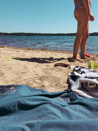 Low section of man standing on beach