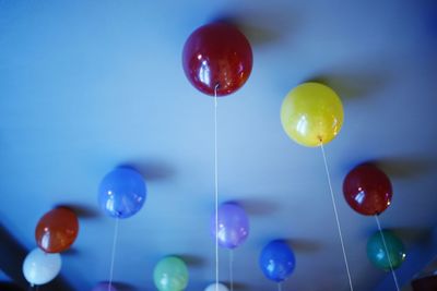 Low angle view of balloons against blue sky