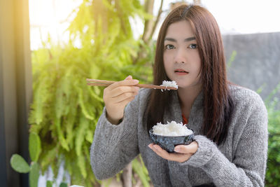 Portrait of young woman eating food