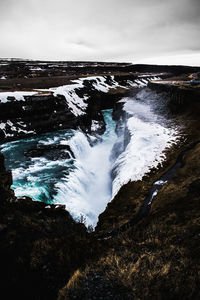 Scenic view of waterfall against sky