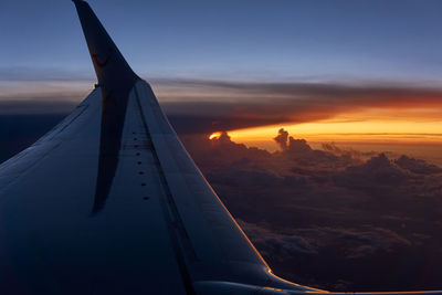 Airplane flying in sky during sunset