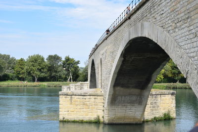 Arch bridge over river against sky