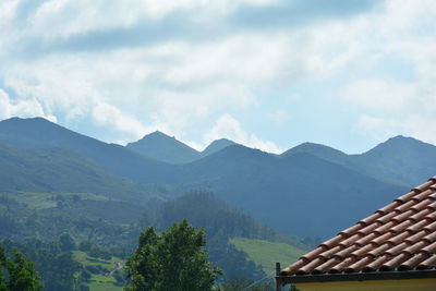 High section of houses and mountains against sky