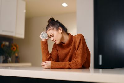 Side view of young woman sitting at home