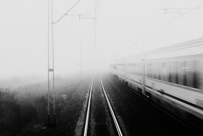 Railroad tracks against sky during foggy weather