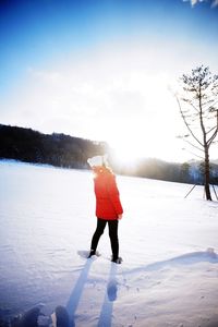 Woman walking on snow covered landscape
