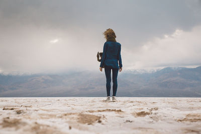 Rear view of woman walking on mountain against sky