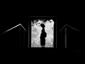 Young woman standing at doorway