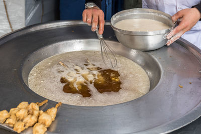 Midsection of person preparing food in kitchen