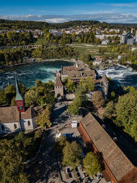 High angle view of town by sea against sky