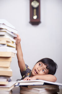 Portrait of young woman reading book on table