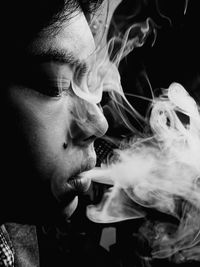 Close-up of man emitting smoke