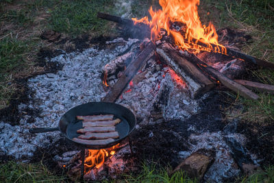 High angle view of meat in pan cooking on campfire