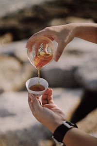 Midsection of person pouring coffee in cup