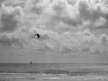 People flying over sea against sky