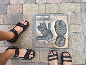 Low section of man standing on sidewalk