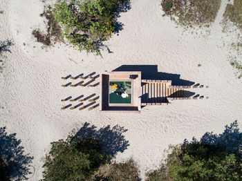 High angle view of friends lying in built structure at beach