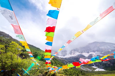 Low angle view of colorful flags against sky