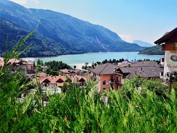 Houses by buildings and mountains against sky