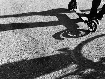 Shadow of man riding bicycle on road