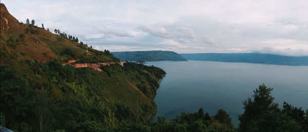 Scenic view of sea and mountains against sky