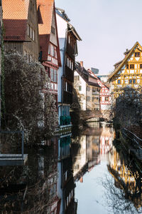 Canal amidst buildings against sky during winter