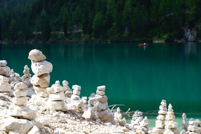 Rocks by lake against trees