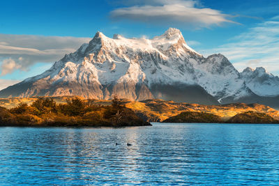 Scenic view of lake and snowcapped mountains against sky