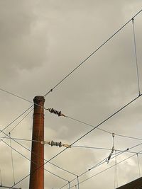 Low angle view of electricity pylon against sky