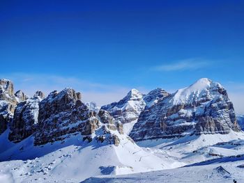 Snowcapped mountains against blue sky