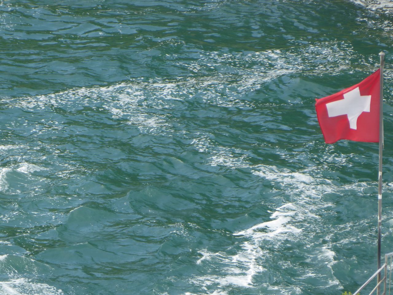 HIGH ANGLE VIEW OF RED FLAG ON SEA