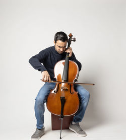 Full length of a man sitting against white background