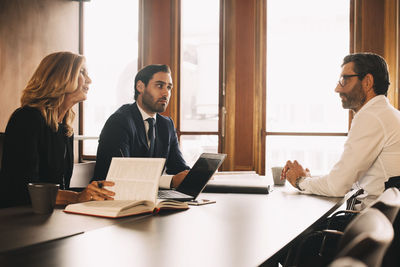 Male and female lawyers discussing with businessman in meeting at office