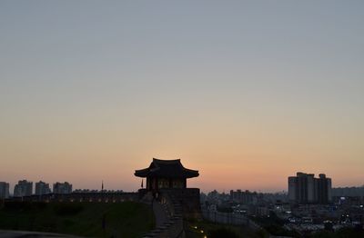 Silhouette buildings against sky during sunset