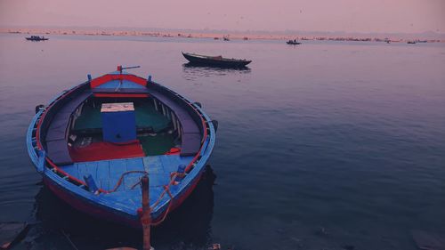 Fishing boat moored in sea against sky