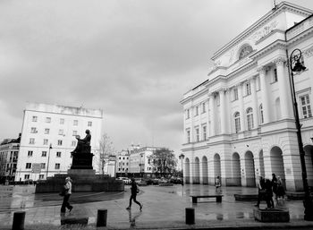 Statue in city against sky