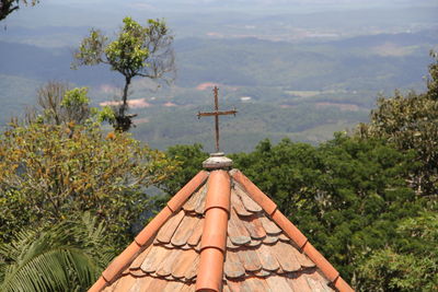 Low angle view of cross on roof of building against sky