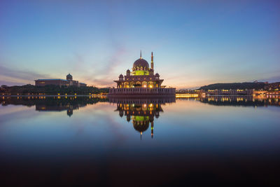 Putra mosque by lake against sky during sunrise