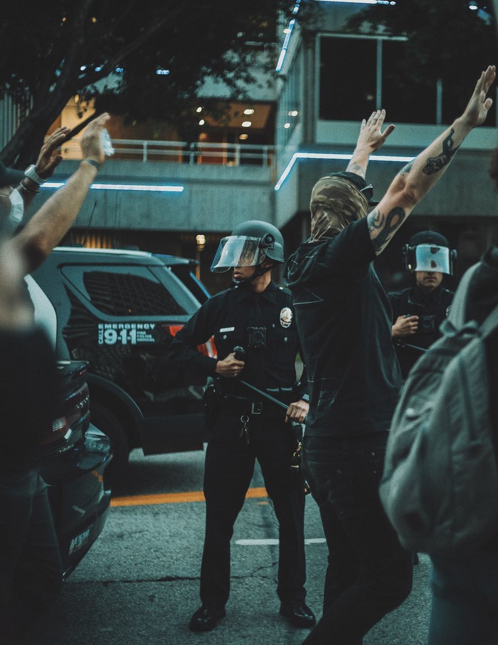 mode of transportation, transportation, car, group of people, motor vehicle, men, adult, city, law, architecture, night, police force, vehicle, arm, government, street