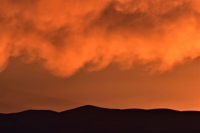 Scenic view of silhouette mountains against romantic sky
